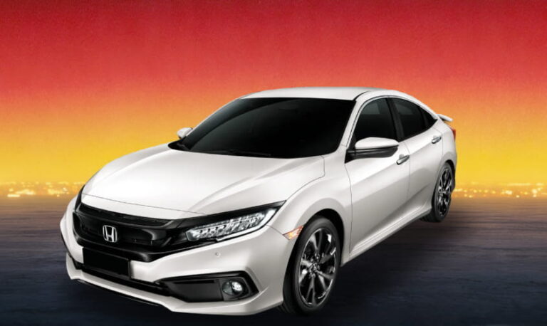 White Honda sedan against a warm evening cityscape background.