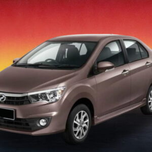 Brown compact sedan car on a dark road at sunset with red and yellow sky.