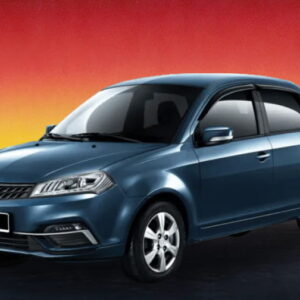 Blue compact sedan car on a dimly lit urban street with a warm evening glow.