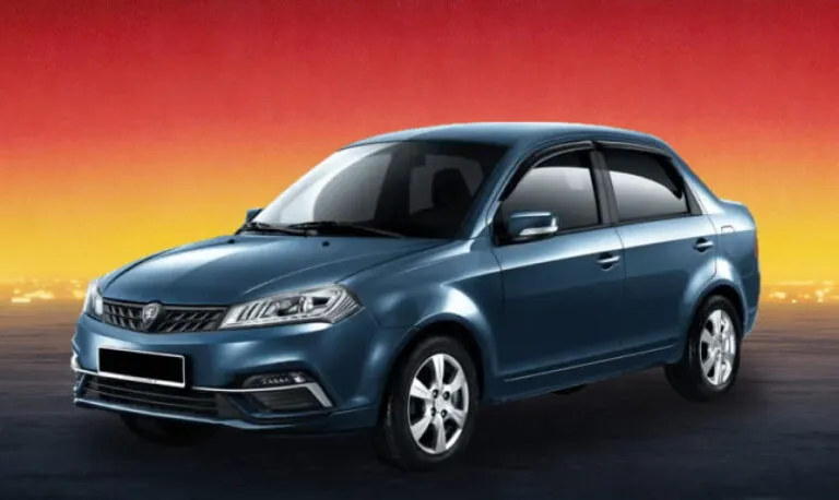 Blue compact sedan car on a dimly lit urban street with a warm evening glow.