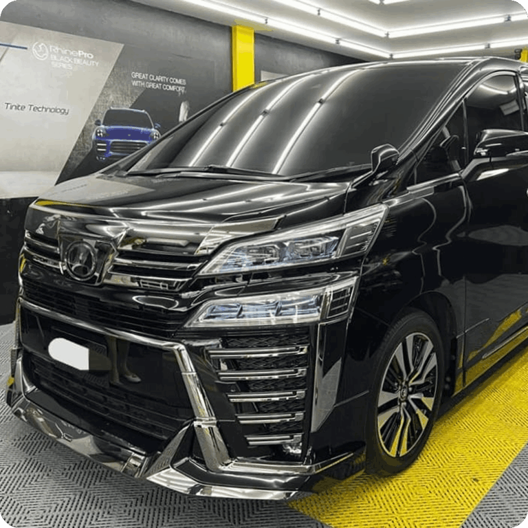 Black Toyota luxury MPV inside a professional car detailing studio.