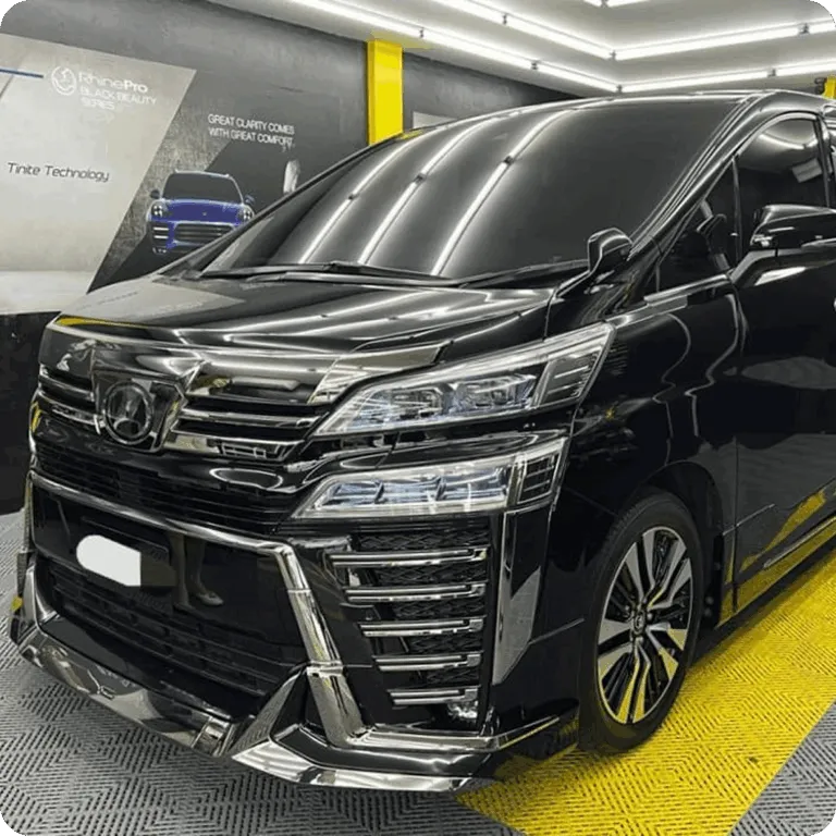 Black Toyota luxury MPV inside a professional car detailing studio.