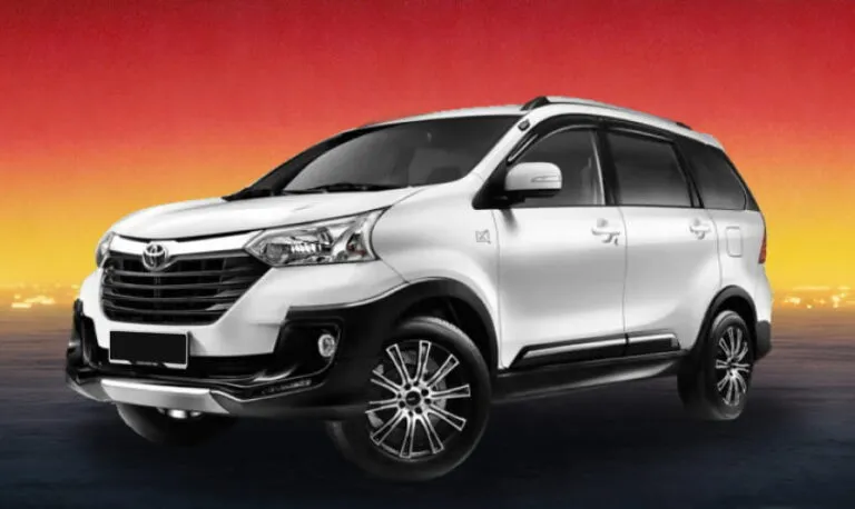 White Toyota MPV against a warm evening skyline background.
