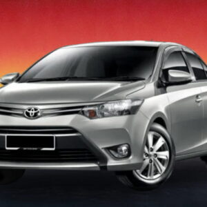 Silver Toyota sedan against a red and yellow sunset background.