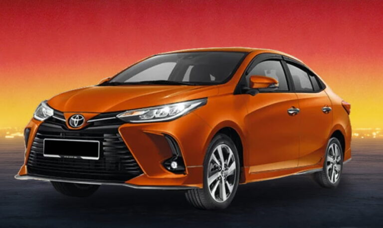 Orange Toyota sedan against a red and yellow sunset background.